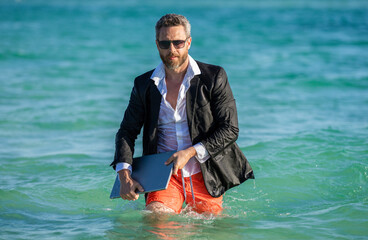 businessman with laptop in formal wear near tropical beach. Hot business summer. business boss...