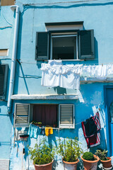 charming mediterranean facade with colorful laundry hanging in procida, italy