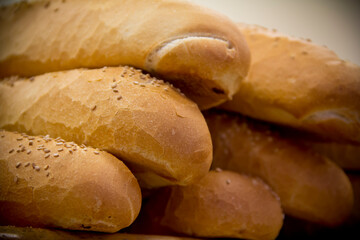 Baguettes stacked on a shelf at a bakery shop, close-up.