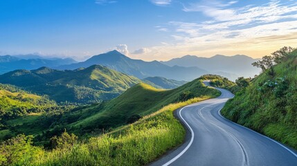 A scenic mountain road winding through lush green hills with a clear blue sky overhead, showcasing the beauty and serenity of a high-altitude drive.