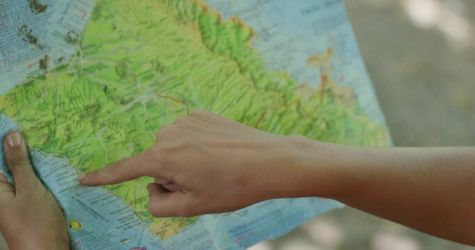 Close up on map of Hawaiian island as woman opens it