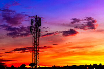 Telecommunication towers with colorful sky as a backdrop in the morning and sunlight reflecting off...