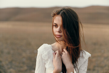 Serenity and beauty woman in white dress standing in field with hands on chest in peaceful setting