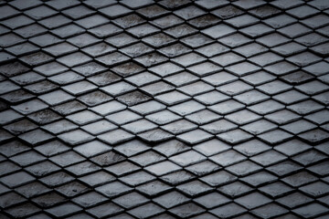 The image is of a roof with a black and white pattern. The roof is made of tiles and has a unique design. The tiles are arranged in a way that creates a sense of depth and texture