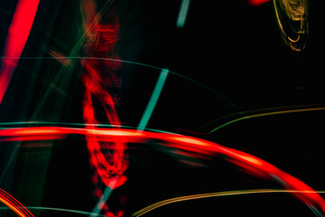 A blurry image of a car with red and green lights. The image has a sense of motion and energy, as if it's capturing a moment in time