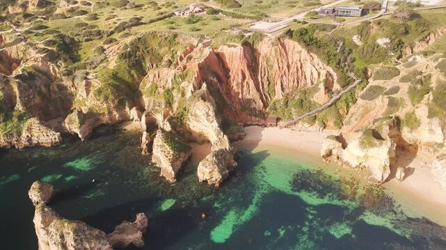 Aerial view of Praia do Camilo with beautiful turquoise water and rocky cliffs, Lagos, Portugal.