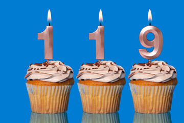 Birthday Cupcakes With Candles Lit Forming The Number 119.