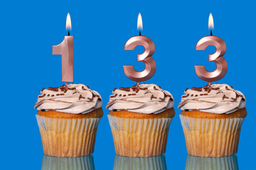 Birthday Cupcakes With Candles Lit Forming The Number 133.