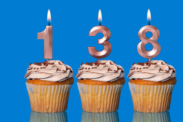 Birthday Cupcakes With Candles Lit Forming The Number 138.