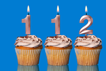 Birthday Cupcakes With Candles Lit Forming The Number 112.