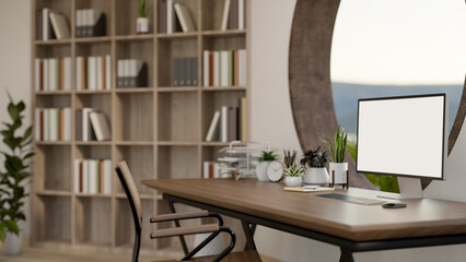 A computer mockup on a wooden desk against a round window in a contemporary room.