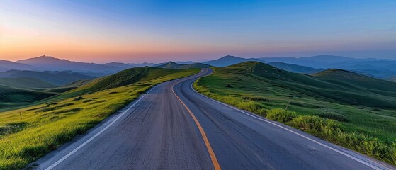 A winding road with lush green grass under sunset sky