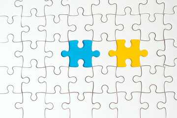 Top view flat lay of white jigsaw puzzle game texture incomplete or missing piece on a blue and...