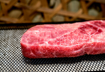 A piece of sirloin meat is sliced and placed on a baking sheet