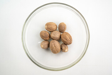 A bowl of nutmeg is sitting on a white table