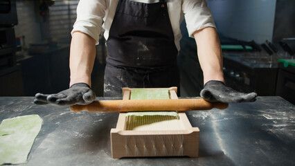 Using The Rolling Pin To Define The Shape Of Green Spaghetti 