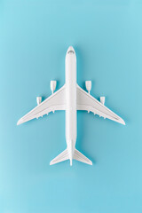  Minimalist white airplane toy model on pastel blue background with copy space