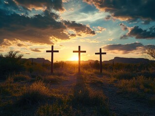 Three crosses in a field at sunset