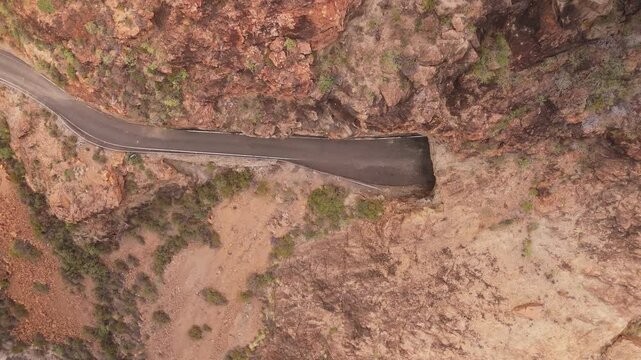 Aerial view of the majestic Presa del Parralillo surrounded by rugged canyon and barren terrain, Candelaria, Spain.