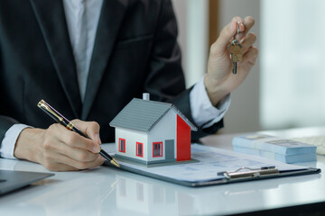 A salesperson explaining the features of a house to a client, aiming to close the sale and finalize the contract.