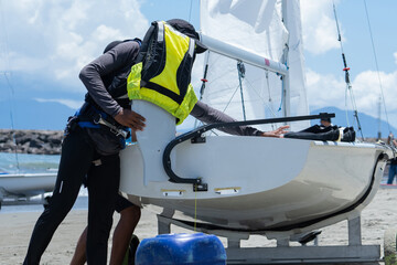 Sailors are preparing a small sailing boat
