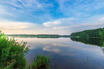 A calm lake with a blue sky in the background