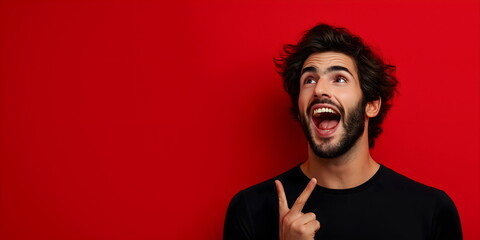 Excited bearded man with curly hair making peace sign against red background. Joyful enthusiasm and youthful energy