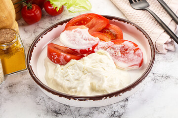 Salad with sliced tomato and stracciatella