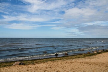 view of the baltic sea with a sandy beach in the foreground and a beautiful blue sky in the background