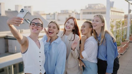 A dynamic group of successful young women joyfully interacts in a bustling coworking space, embracing teamwork and showcasing their creativity in an inspiring professional setting