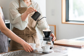 カフェ・コーヒーショップ・喫茶店でコーヒーを淹れるバリスタ・焙煎士の女性スタッフ・マスター
