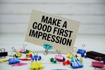 Make A Good First Impression text on paper card with stationary on wooden background