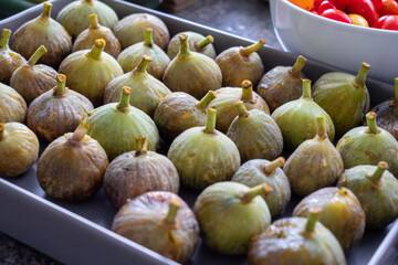 A tray of green figs with brown tips