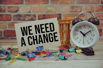 We need a change text on paper card with alarm clock and stationary on wooden background