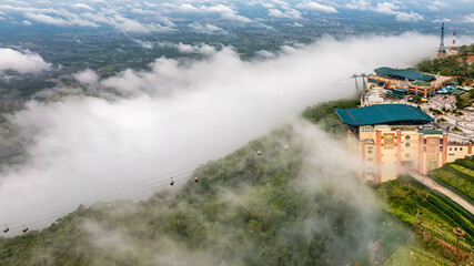 Ba Den mountain tourist area. The longest cable car at Ba Den mountain in cloud sky. Below is forest.