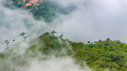 Ba Den mountain tourist area. The longest cable car at Ba Den mountain in cloud sky. Below is forest. © Hien Phung