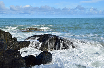 The sea waves are running over the rocks.