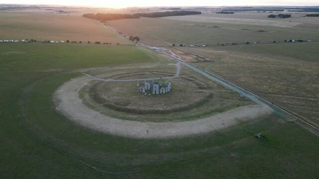 Aerial view of stonehenge at sunset surrounded by a beautiful meadow, amesbury, united kingdom.