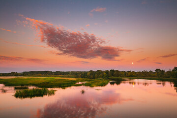 Fototapeta premium River Landscape In Belarus Or European Part Of Russia In Sunset Time Of Summer Evening. Moon Rising Over Water Lake Or River. Nature At Sunny Evening.