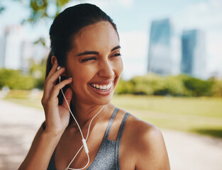 Fitness, happy and woman in park with earphones for exercise, marathon training and running. Sports, music and person listening to workout playlist, audio and radio for wellness, health and cardio