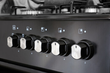 Close up of control panel with knobs for gas stove in home kitchen.