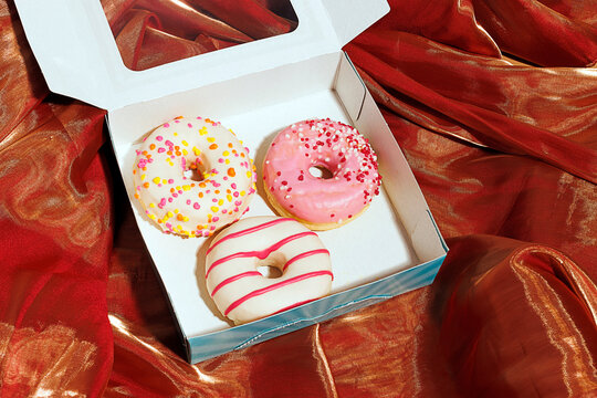Open donut box on brown iridescent cloth
