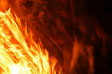 fire at night. flames on a black background. fantastic view of the raging element of fire. blurred...