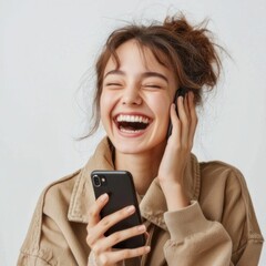 Fototapeta premium A person wearing a casual outfit, holding a smartphone up to their ear while laughing. The white background keeps the focus on the person and their joyful expression. The high-resolution photo
