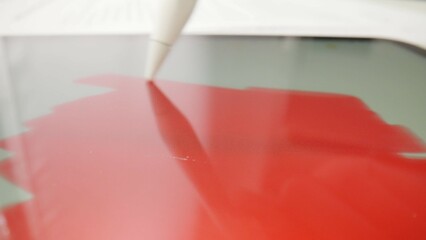 The stylus paints the tablet screen with red color.