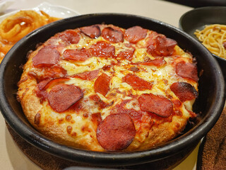Ham cheese pizza stretches on a tray ready to serve.