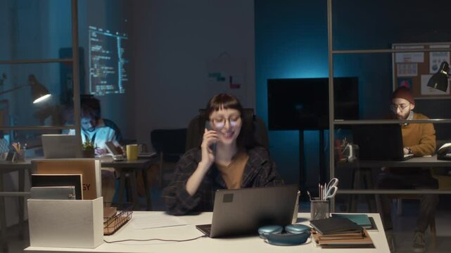 Timelapse shot of team of young diverse IT specialists working in office at nightime, completing software project and troubleshooting system issues