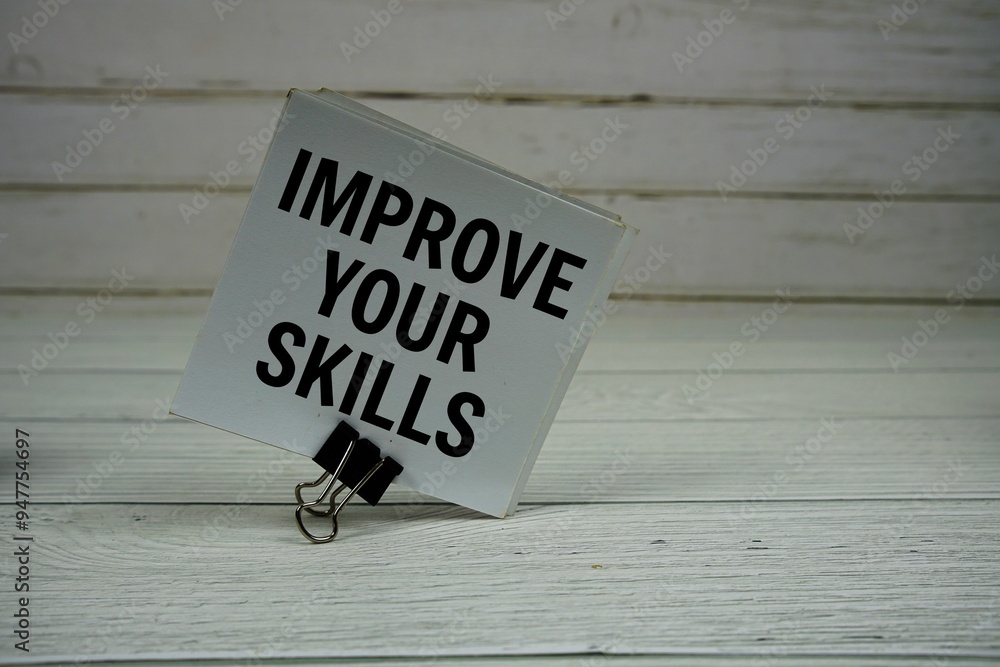 Aufkleber improve your skills text message write on sticky note on wooden background