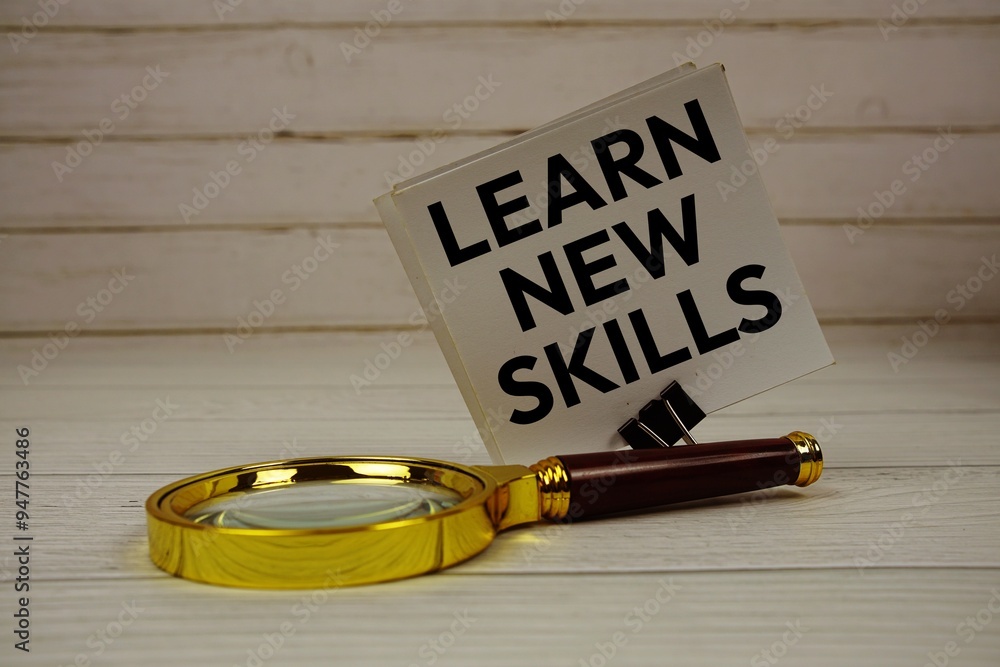 Aufkleber learn new skills text message on sticky note with magnifying glass on wooden background