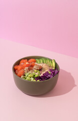 poke bowl with salmon on pink background